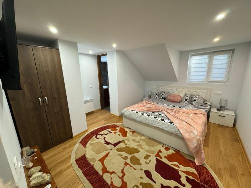 a bedroom with a bed and a rug at Casa Vio in Buşteni