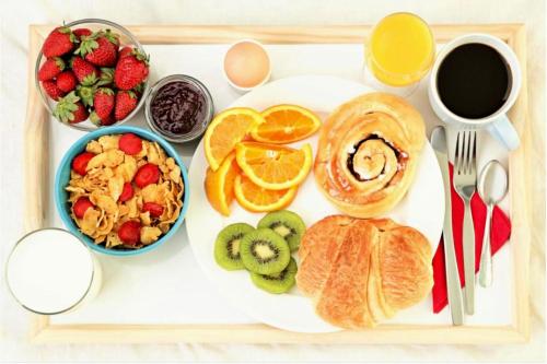 a tray of breakfast food with fruit and a cup of coffee at Pool - WiFi - Parking - Best Location ! in Kissimmee