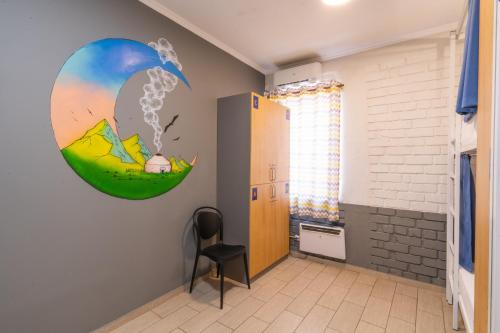 a room with a chair and a painting on the wall at ololoFreelander Hostel&Coworking in Bishkek