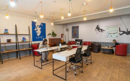 two people sitting at tables in a waiting room at ololoFreelander Hostel&Coworking in Bishkek