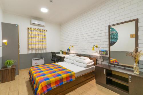 a bedroom with a bed and a desk and a mirror at ololoFreelander Hostel&Coworking in Bishkek