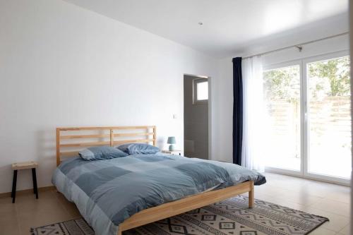 a bedroom with a large bed and a large window at Barra Beach House 2 in Gafanha da Nazaré