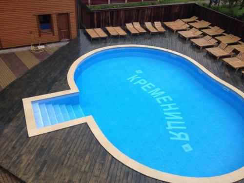 a large swimming pool with lounge chairs next to it at Кремениця in Rivna