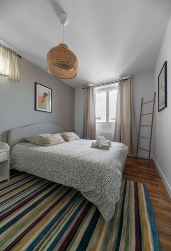 a bedroom with a large bed and a rug at Résidence Léon Blum - Appartements design - Parking in Clermont-Ferrand