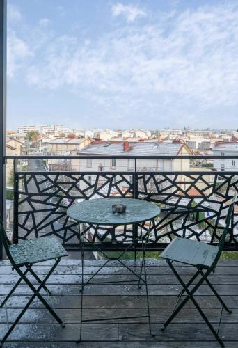 a table and chairs on a balcony with a view at Résidence Léon Blum - Appartements design - Parking in Clermont-Ferrand