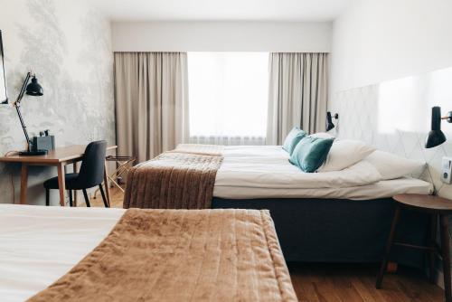 a hotel room with two beds and a desk at Quality Hotel Ekoxen in Linköping