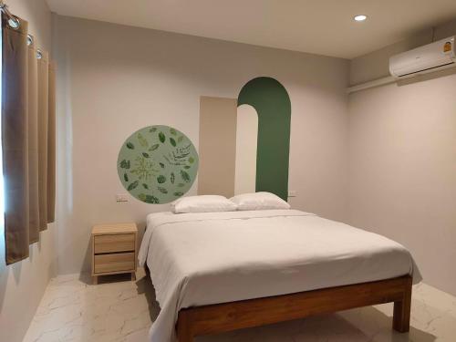 ein Schlafzimmer mit einem Bett mit einem grünen Bogen darüber in der Unterkunft Chiang Khan Dwelling in Chiang Khan