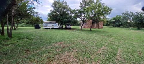 an rv and a truck parked in a field at El Rancho Grande in Warmbaths