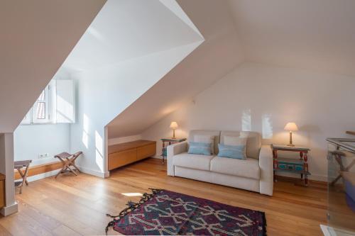 un soggiorno con divano bianco e cuscini blu di Duplex in Lisbon old town, 321 a Lisbona