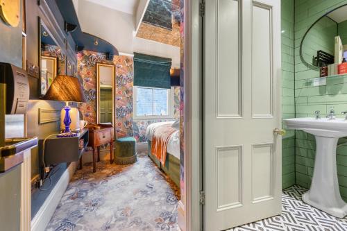 a bathroom with green walls and a sink and a bed at Clementine's Guest House in York