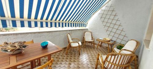 d'un balcon avec une table et des chaises en bois ainsi qu'une fenêtre. dans l'établissement CASA PER VACANZE ANGELO, à Castelsardo