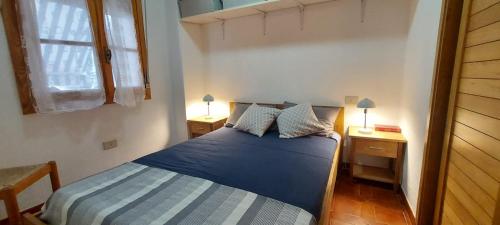 - une chambre avec un lit bleu et 2 tables de nuit dans l'établissement CASA PER VACANZE ANGELO, à Castelsardo