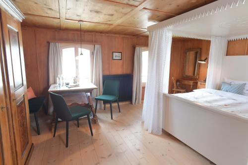 a bedroom with a bed and a table and chairs at Casa Fausta Capaul in Brigels