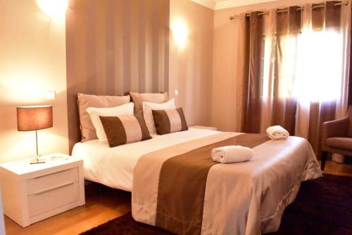 a bedroom with a large bed with towels on it at The Albufeira Concierge - Villa Santa Eulalia in Olhos de Água