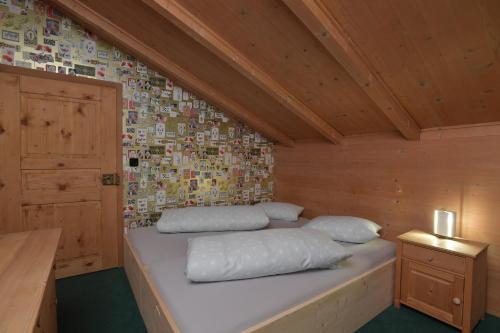 a room with a bed in a wooden attic at Casa Fausta Capaul in Brigels