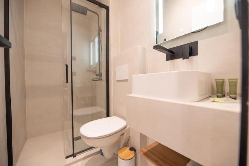 une salle de bain blanche avec toilettes et douche dans l'établissement Cosy flat / Tour Eiffel Area, à Paris