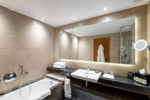 a bathroom with a tub and a sink and a mirror at InterContinental London - The O2 in London