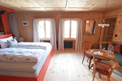 a bedroom with a bed and a table and chairs at Casa Fausta Capaul in Brigels
