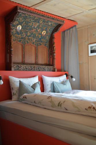 a bedroom with a large bed with a red headboard at Casa Fausta Capaul in Brigels