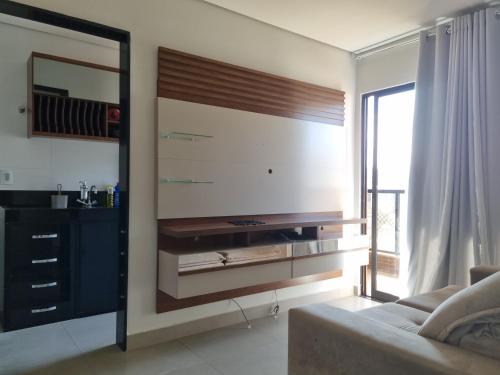 a living room with a couch and a large tv at Apartamento luxo no centro in Ubá