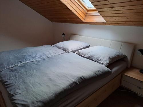 - un lit avec 2 oreillers dans une chambre dans l'établissement Plapperer`s Fewo, à Schernfeld