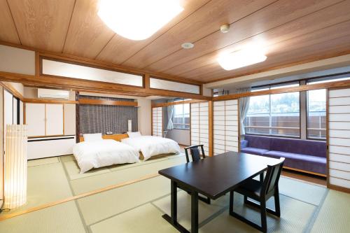 1 dormitorio con 1 cama, mesa y sillas en Arimakan, en Kaminoyama