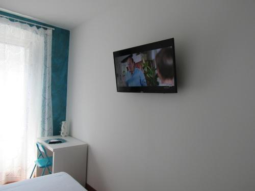 einen TV an der Wand eines Schlafzimmers in der Unterkunft Smart Rooms in Triest