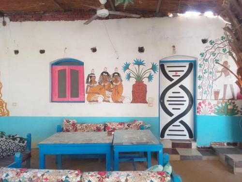 a room with a table and paintings on the wall at Al Salam Camp in Luxor
