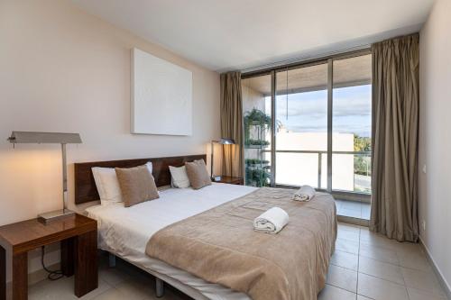 - une chambre avec un grand lit et une grande fenêtre dans l'établissement TAC - Salgados Beach Prime Pool Resort, à Guia