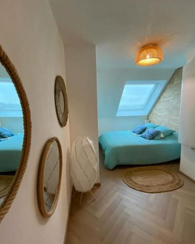 une chambre avec un lit et un miroir au mur dans l'établissement La Félicita Calais Plage, à Calais