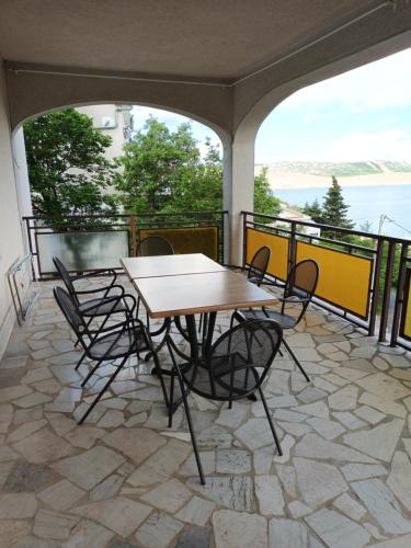 un patio con tavolo e sedie sul balcone. di Vila Bozica a Jadranovo