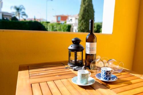 a table with a bottle of wine and two cups at TAC - Alcantarilha House in Alcantarilha