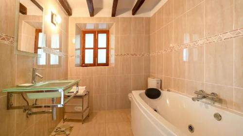 a bathroom with a bath tub and a sink at Sol y Montes in Fornalutx