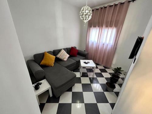 a living room with a couch and a checkered floor at An oasis close to the beach. in Martil