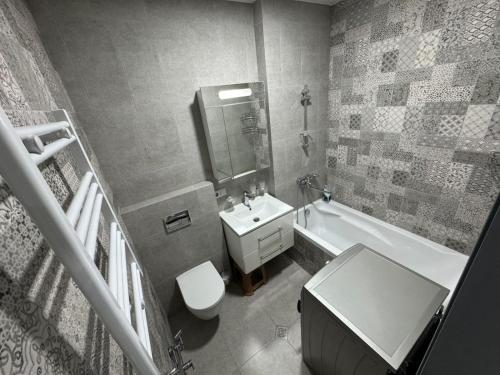 a bathroom with a sink and a toilet and a bath tub at RS apartment in Batumi