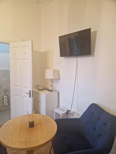 a living room with a blue chair and a table at Lovely Studio - perfect weekend stay in Cork in Cork