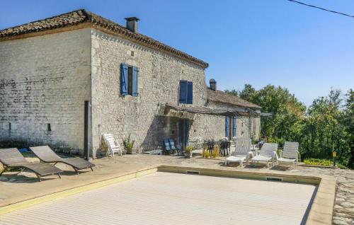 a group of chairs and a swimming pool in front of a building at Stunning Home In Fauroux With Wifi in Fauroux