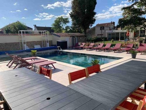- une piscine avec des tables de pique-nique et des chaises à côté dans l'établissement Maison 2 piscines int/ext, spa, à Gueugnon