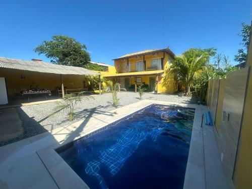 a house with a swimming pool in front of a house at Pousada Alto da Marina in Búzios