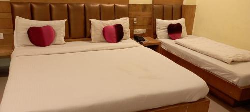 two beds in a hotel room with red pillows at Hotel golden gate dx in New Delhi