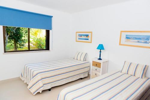 um quarto com 2 camas e uma janela em The Albufeira Concierge - Villa Praia São Rafael em Albufeira