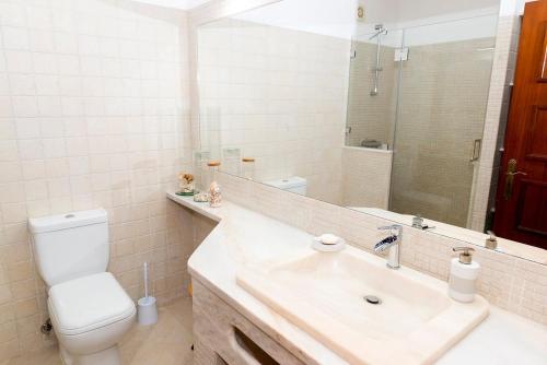 uma casa de banho com um lavatório, um WC e um espelho. em The Albufeira Concierge - Villa Praia São Rafael em Albufeira