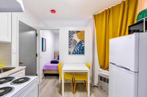ニューヨークにあるPeaceful Apartment in Lower Manhattan New Yorkの小さなキッチン(白いテーブル、黄色の椅子付)