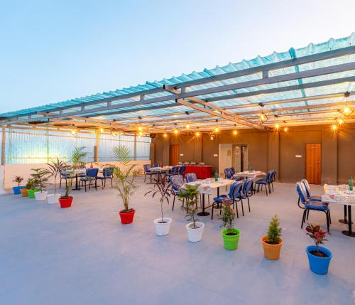 a patio with tables and chairs and potted plants at Treebo Pure Earth Stay, Vijay Nagar in Indore
