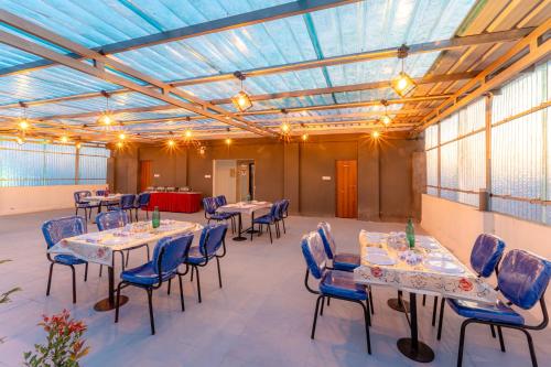 a room with tables and chairs and a glass ceiling at Treebo Pure Earth Stay, Vijay Nagar in Indore