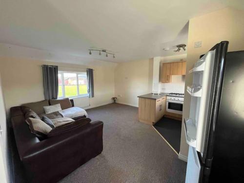 a living room with a couch and a kitchen at 2 bed coach house flat Hereford in Hereford