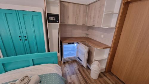 een kleine kamer met een bed en een blauwe kast bij OPG VIDA in Garešnica
