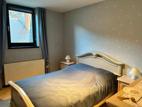 een slaapkamer met een bed, 2 tafels en een raam bij Le Reflet Meuse in Dinant