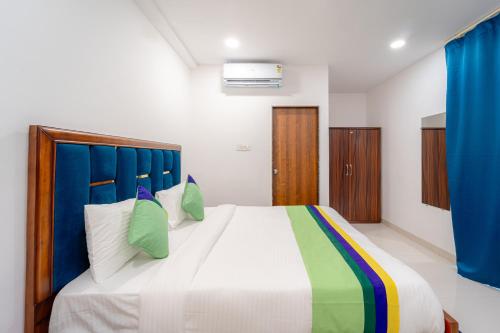 a bedroom with a large bed with a blue headboard at Treebo Pure Earth Stay, Vijay Nagar in Indore