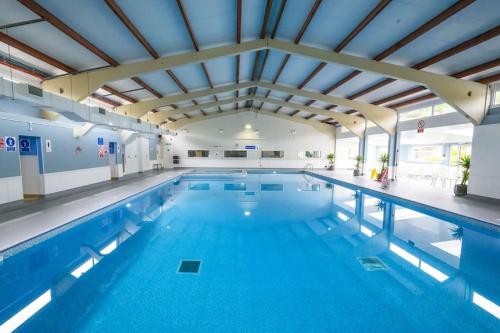 a large indoor swimming pool with blue water at FRONT LINE Chalet with OPEN Sea Views & Swimming Pool in Kingsdown No14 in Kingsdown